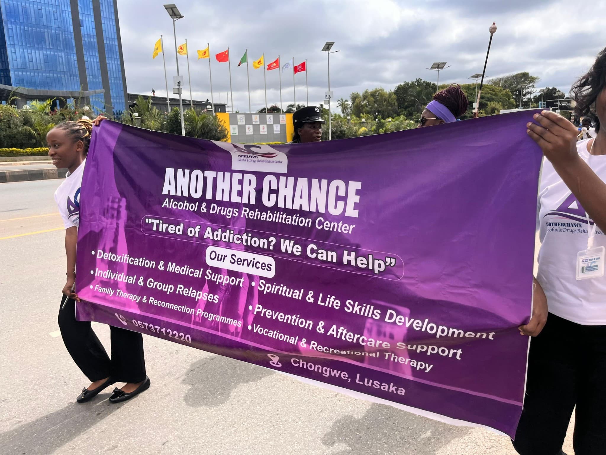 Another Chance team carrying a purple awareness banner during a public outreach march